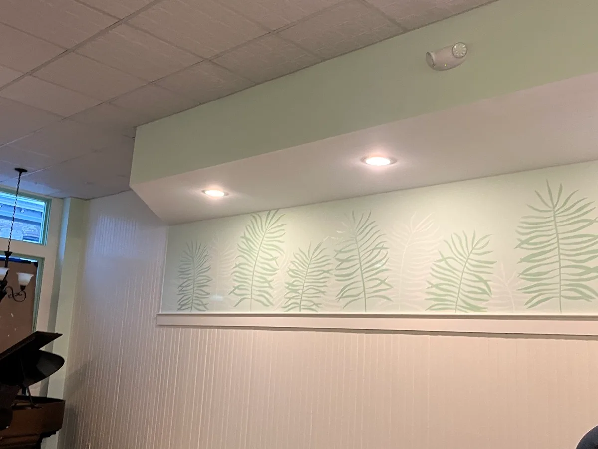 Finished pale green interior mural with hand-painted white and sage fern fronds