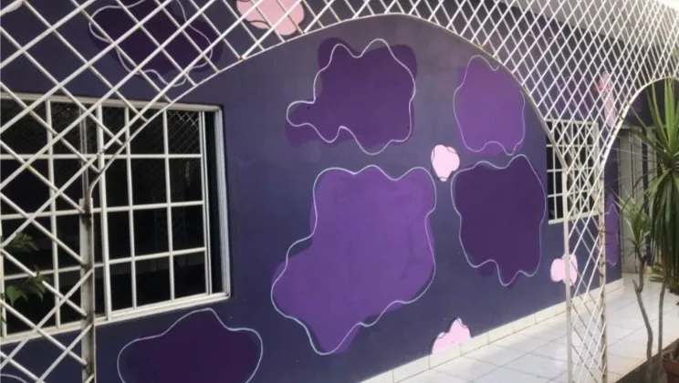Purple outdoor floral mural wrapping around windows and white latticework