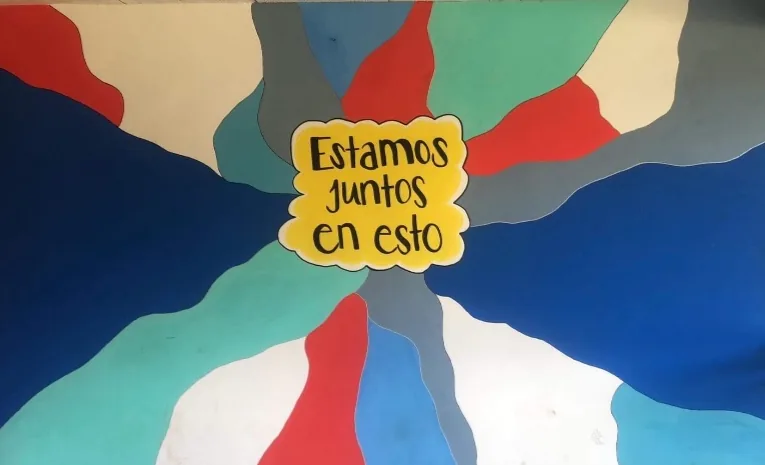 Colorful abstract wall mural hand lettered with Estamos juntos en esto